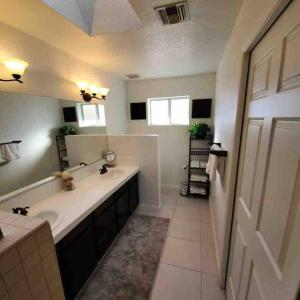a bathroom with a sink and a large mirror at Lake Havasu Retreat w pool Everything Nearby! in Lake Havasu City
