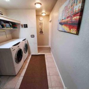 a washing machine in a laundry room with a painting on the wall at Lake Havasu Retreat w pool Everything Nearby! in Lake Havasu City