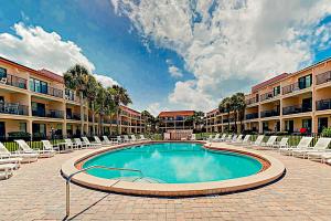 a swimming pool in a courtyard with lounge chairs at Sea Fair Condo Unit 12128 in St. Augustine