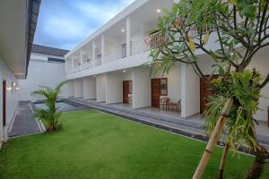 an empty courtyard of a house with a lawn at Maisaba Canggu Hotel & Coworking Space in Canggu