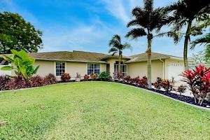 una casa con un gran patio con palmeras en The Albatross on 14th, en Cabo Coral