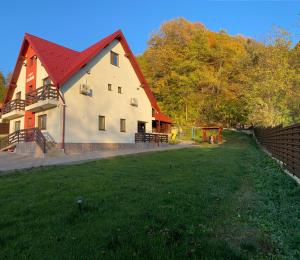 a large white building with a red roof at Casa Elysium in Vălenii de Munte