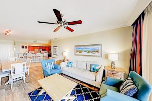 uma sala de estar com um sofá e uma ventoinha de tecto em Emerald Grande em Destin