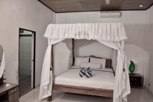 a bedroom with a bed with a canopy at Warung ombak homestay in Amed
