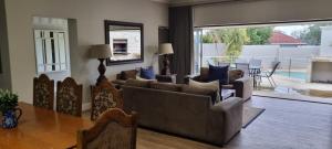 a living room with a couch and a table and a dining room at 6 on Western Guest House in East London