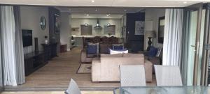 a living room with a couch and a table and chairs at 6 on Western Guest House in East London