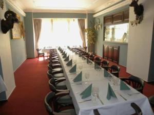 a long room with a long table and chairs at Hotel Černý Orel Žatec in Žatec