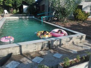 two girls are in an outdoor swimming pool at บ้านสวนปวิชญา เกษตรอินทรี in Fang