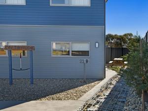 a blue building with a sign in front of it at T Bar on Twynam - Modern 2BR Apartment l WiFi l Netflix l BBQ l Smart TV l Air-Con in Jindabyne