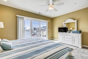 a bedroom with a bed and a tv and a window at Bella Sun 201a in Ocean City