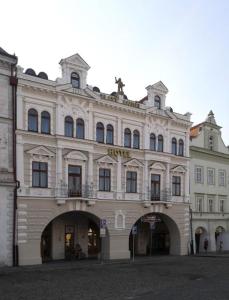 un gran edificio blanco con un arco delante de él en Hotel Zlatý Anděl, en Žatec