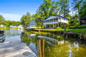 a house on a river with a boat in the water at Drawbridge Rd 38 in Ocean Pines