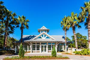 a building with palm trees in front of it at Grande Pointe Driftwood in Inlet Beach