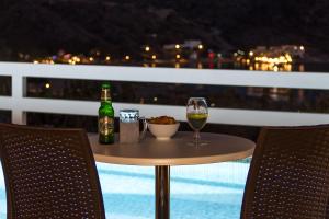 una mesa con una botella de vino y una copa en Manthos Place, en Mylopotas