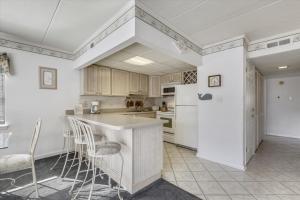 una cucina con armadietti bianchi e frigorifero bianco di Diamond Beach II a Ocean City
