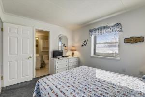 a bedroom with a bed and a television and a bathroom at Diamond Beach II in Ocean City