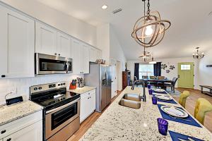a kitchen with white cabinets and a dining room at Trade Wind Cabana in Saint Augustine