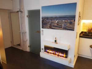 a fireplace in a room with a picture on the wall at kleine Düne in Cuxhaven