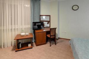 a hotel room with a desk with a tv and a mirror at Tchernomorye Resort in Nebug