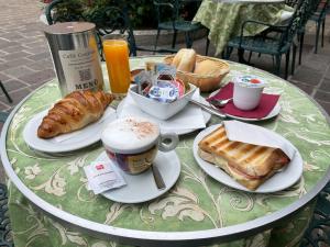 a table with a breakfast of coffee and pastries on it at Hotel Du Lac Menaggio in Menaggio