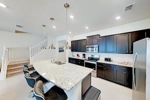 a large kitchen with a counter and a refrigerator at Windsor Island Resort 237 in Davenport