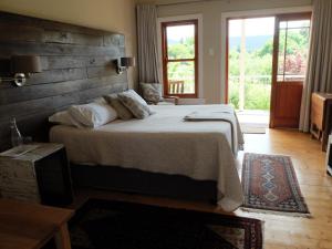 a bedroom with a large bed and a large window at Doorways in Barrydale