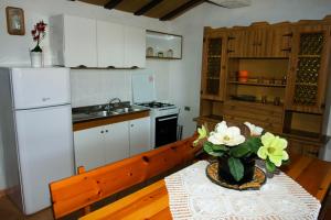 una cocina con una mesa con un jarrón de flores. en Casa Vacanze San Lorenzo, en Agerola