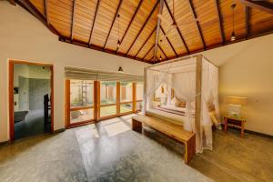 a bedroom with a bed with a canopy at The Spice Trail in Arugam Bay