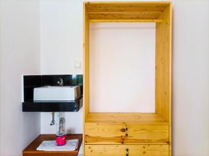 a bathroom with a sink and a wooden cabinet at Ancala Uluwatu in Uluwatu