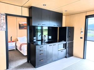 eine Küche mit einem schwarzen Kühlschrank im Zimmer in der Unterkunft GH Twizel Holiday Cottage in Twizel