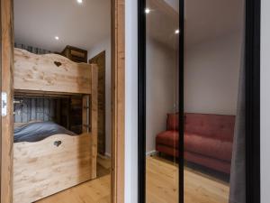 a bedroom with a bunk bed and a red couch at Appartement La Clusaz, 3 pièces, 6 personnes - FR-1-304-274 in La Clusaz