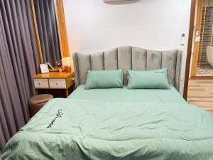 a bedroom with a large bed with blue pillows at Mơ Màng House Tam Đảo - Venue Travel in Tam Ðảo