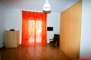 Habitación con cortina de color naranja y tocador en Casa Vacanze San Lorenzo en Agerola