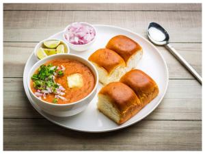 un plato de comida con un tazón de sopa y pan en JenJon Best Retreat Chalets at Sparsh Karjat Resort with optional SWIMMING POOL, en Karjat