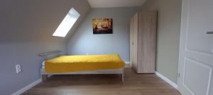 ein Schlafzimmer mit einem gelben Bett in einem Zimmer in der Unterkunft zum Kranichblick in Glinstedt + 3 Fotos