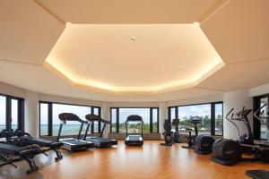 a gym with a row of treadmills and exercise bikes at Sheraton Okinawa Sunmarina Resort in Onna