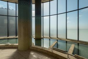 a swimming pool in a building with glass windows at Sheraton Okinawa Sunmarina Resort in Onna