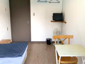 a bedroom with a bed and a table and a table and chair at 五岳庵 in Shinano