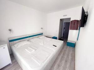 1 dormitorio con 1 cama blanca grande en una habitación en Hotel Minerva, en Eforie Nord