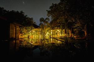 a night time view of a pond with lights at The Spice Trail in Arugam Bay
