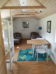 Cette chambre comprend une table et des lits superposés. dans l'établissement Hærvejsly - Perfekt familiebase til oplevelse af Sydjylland, à Give
