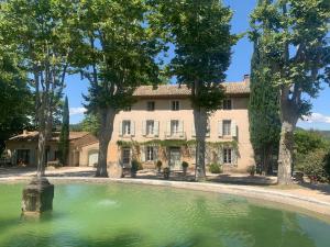 a large house with a pond in front of it at Villa du defens in Saint-Martin-de-Castillon