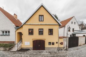 uma casa amarela com uma porta castanha numa rua em Konekt Apartment em Český Krumlov