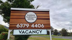 
a sign on a pole with a sign on the side of it at Kandos Fairways Motel in Kandos
