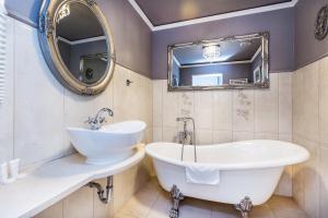 a bathroom with a tub and a sink and a mirror at Willa Excelsior in Zakopane
