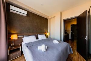 a bedroom with a bed with two white towels on it at Sani Apart Hotel in Tbilisi City