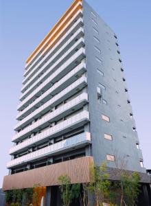 un edificio alto de color gris con ventanas laterales en 谷町君 HOTEL 恵美須町72, en Osaka