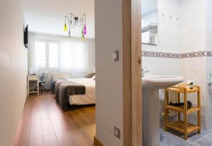 a bathroom with a bed and a sink in a room at Hotel Costa Verde in Gijón