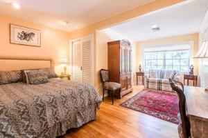 a bedroom with a bed and a chair and a window at Unwind Island 3 Bedrooms 3 full washrooms in West Palm Beach