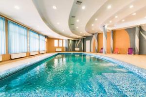 a large swimming pool in a hotel room at Koncha-Zaspa Spa Hotel in Svalyava